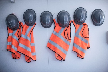 A group of safety vests and helmets